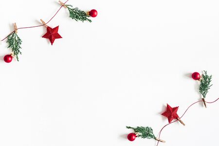 Christmas composition. Garland made of red balls and fir tree branches on white background. Christmas, winter, new year concept. Flat lay, top view, copy spaceの写真素材