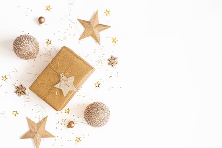Christmas composition. Gift box, golden decorations on white background. Christmas, winter, new year concept. Flat lay, top view, copy spaceの写真素材