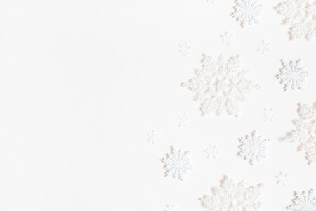 Christmas composition. Frame made of white snowflakes on white background. Christmas, winter, new year concept. Flat lay, top view, copy spaceの写真素材