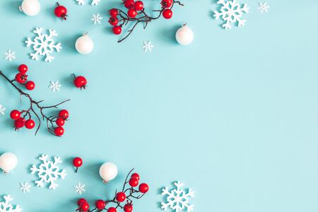Christmas or winter composition. Snowflakes and red berries on blue background. Christmas, winter, new year concept. Flat lay, top view, copy spaceの写真素材