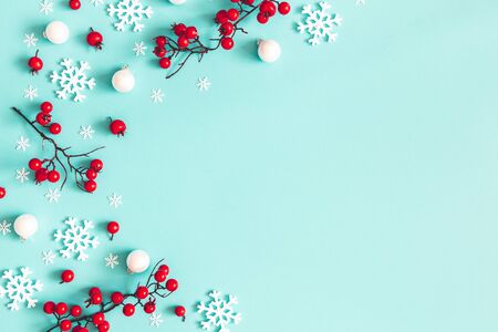 Christmas or winter composition. Snowflakes and red berries on blue background. Christmas, winter, new year concept. Flat lay, top view, copy spaceの写真素材