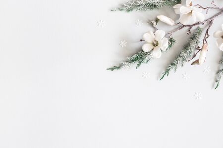 Christmas composition. Fir tree branches, flowers on pastel gray background. Christmas, winter, new year concept. Flat lay, top view, copy spaceの写真素材