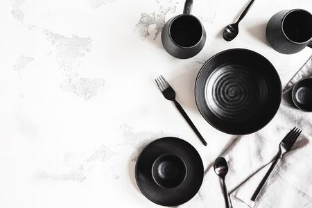 Black stylish tableware on white background. Flat lay, top viewの写真素材