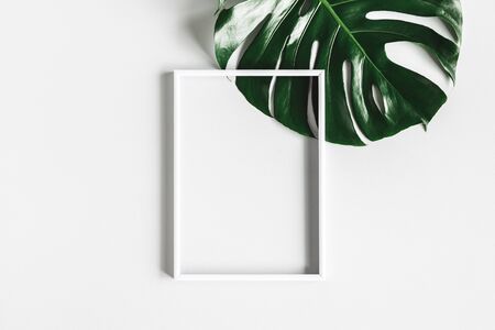Summer composition. Tropical leaf, photo frame on white background. Summer concept. Flat lay, top view, copy spaceの写真素材