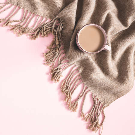 Autumn composition. Cup of coffee, plaid on pink background. Autumn, fall, winter concept. Flat lay, top viewの写真素材