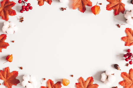 Autumn composition. Frame made of flowers, maple leaves on gray background. Autumn, fall, thanksgiving day concept. Flat lay, top viewの写真素材