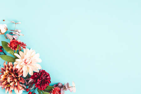 Autumn composition. Dried flowers and leaves on blue background. Autumn, fall, thanksgiving day concept. Flat lay, top viewの写真素材