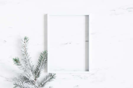 Christmas composition. Fir tree branches, photo frame on marble background. Christmas, winter, new...