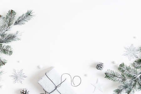 Christmas composition. Gift box, fir tree branches, decorations on white background. Christmas, winter, new year concept. Flat lay, top view, copy spaceの写真素材