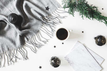 Christmas decorations, plaid, fir tree branch, notebook, cup of coffee on white background. Christmas, new year, winter concept. Flat lay, top viewの写真素材