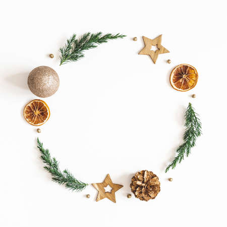 Christmas composition. Wreath made of fir tree branches, golden decorations on white background. Christmas, winter, new year concept. Flat lay, top viewの写真素材