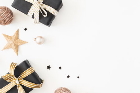 Christmas composition. Gifts, black and golden decorations on white background. Christmas, winter, new year concept. Flat lay, top viewの写真素材
