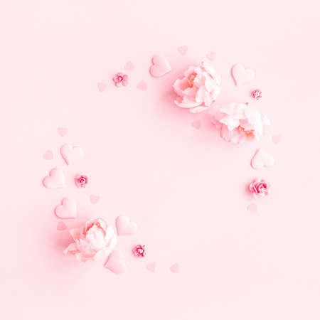 Valentine's Day background. Wreath made of pink flowers, hearts on pastel pink background. Valentines day concept. Flat lay, top view, copy spaceの写真素材