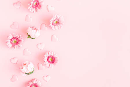 Valentine's Day background. Pink flowers, hearts on pastel pink background. Valentines day concept. Flat lay, top view, copy spaceの写真素材