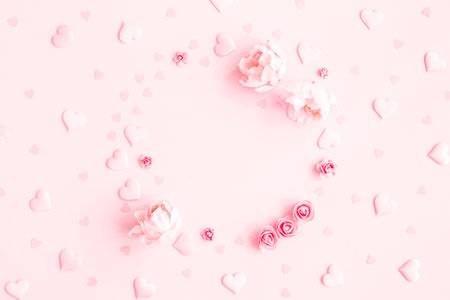 Valentine's Day background. Frame made of pink flowers, hearts on pastel pink background. Valentines day concept. Flat lay, top view, copy spaceの写真素材