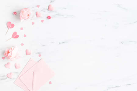 Valentine's Day background. Pink flowers, envelope, hearts on marble background. Valentines day concept. Flat lay, top viewの写真素材