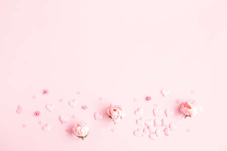 Valentine's Day background. Frame made of pink flowers, hearts on pastel pink background. Valentines day concept. Flat lay, top view, copy spaceの写真素材