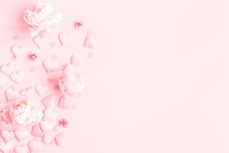 Valentine's Day background. Frame made of pink flowers, hearts on pastel pink background. Valentines day concept. Flat lay, top view, copy spaceの写真素材