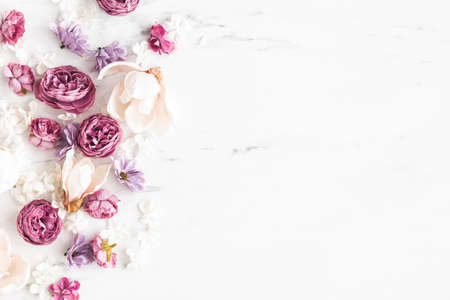 Flowers composition. White and purple flowers on marble background. Flat lay, top viewの写真素材