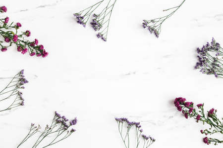 Flowers composition. Purple flowers and eucalyptus leaves on marble background. Flat lay, top viewの写真素材