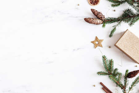 Christmas composition. Christmas gift, fir tree branches, golden decorations on marble background. Flat lay, top view, copy spaceの写真素材
