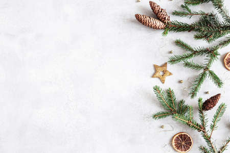 Christmas composition. Fir tree branches, christmas golden decorations on gray background. Flat lay, top view, copy spaceの写真素材