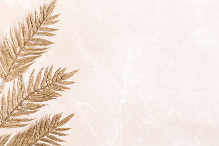 Christmas composition. Golden leaves onmarble beige background. Christmas, winter, new year concept. Flat lay, top view, copy spaceの写真素材