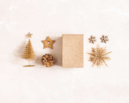 Christmas composition. Golden decorations on marble beige background. Christmas, winter, new year concept. Flat lay, top viewの写真素材