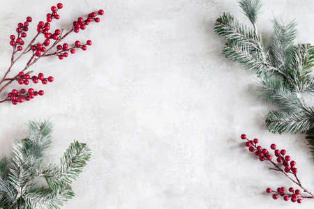 Christmas composition. Fir tree branches, red berries on gray background. Christmas, winter, new year concept. Flat lay, top view, copy spaceの写真素材