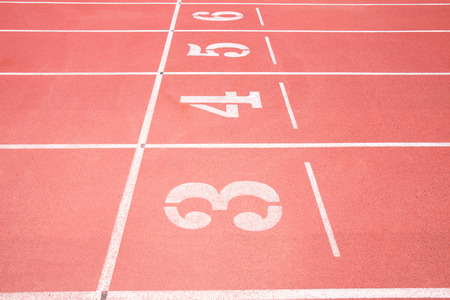 Red treadmill at the stadium with the numbering from three fourth five sixの写真素材