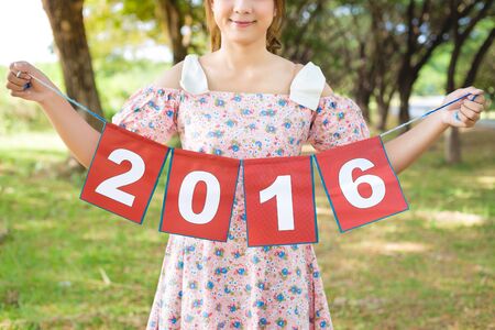 smile of cute woman hand holding paper sign 2016, happy new year