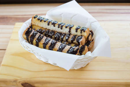 Fresh Croissant or Bread with chocolate topping on wooden tableの写真素材