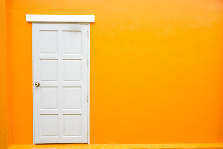 White door classic vintage on the color orange wall backgroundの写真素材