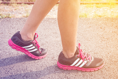 closeup of feet for woman runner athlete  running on the road or street, healthy lifestyle concept pastel or vintage style color.の写真素材