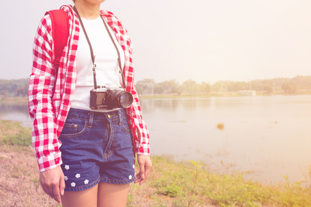 young woman girl is travel with backpack and camera in pastel or vintage style color. travel concept. copy space backgroundの写真素材