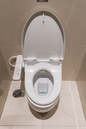 white flush toilet with electronic control in modern bathroom interiorの写真素材