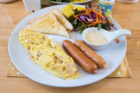 Closeup of omelet with orange juice, croissants, cereals and fruits on wooden table. Balanced diet. Select focusの写真素材