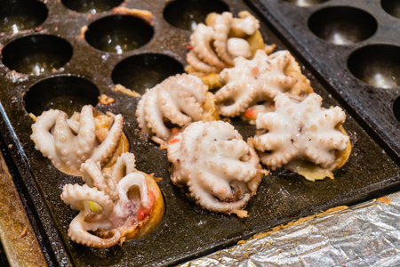 Close up of Takoyaki with squid, Making Takoyaki by big squid select focus. Japanese food background or texture.の写真素材