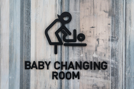 Black symbol for women and baby, baby changing room on wood background.の写真素材