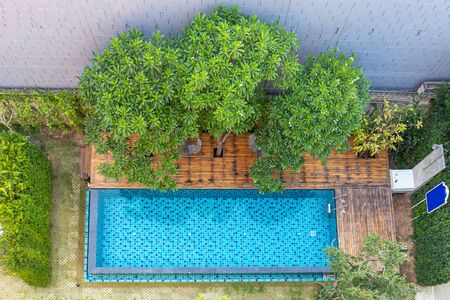 Top view of Swimming pool with stair at hotel with decorated with trees and chairs for relaxingの写真素材