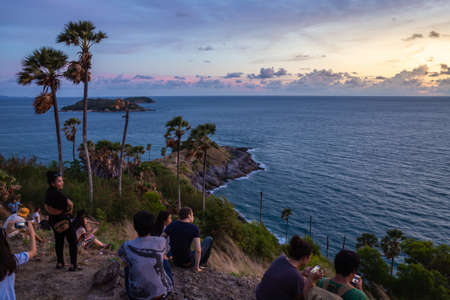 Phuket, Thailand - May 2015: Sunset at Promthep Cape, the southernmost point of Phuket island. People watch the sunset on the promenade of Promthep Cape with Palms, sea and skyのeditorial素材