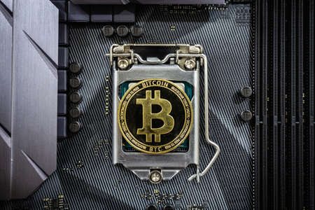 Close up of Golden bitcoin on CPU socket in computer. Crypto Currency concept and online trading of...