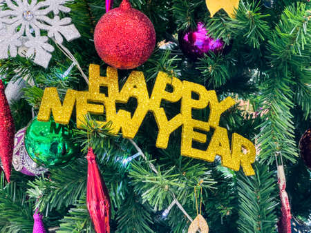 Christmas tree decorated with multicolored balls and snowmen with Happy new year signs and...