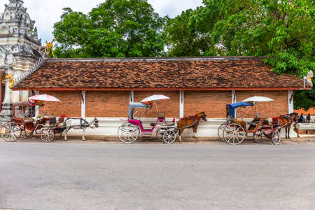 A horse-drawn carriage waiting to serve in front of Wat Phra That Lampang Luang, Lampang, Thailandのeditorial素材