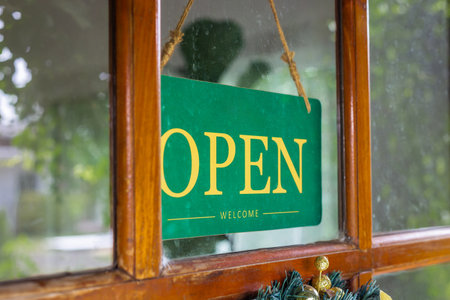 The sign was opened on the wooden door in front of the cafe.の写真素材