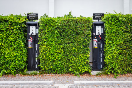 Hua Hin, Prachuap Khiri Khan Province Thailand - 9 July  2023 :The electric car charging station by Porsche in the middle of green trees symbolizes clean energy and environmental protection.のeditorial素材