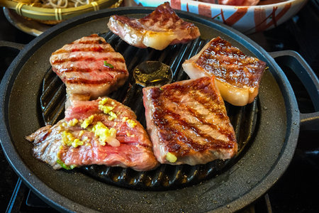 Large pieces of marbled wagyu beef grilled on a pan are a high quality and famous premium beef from Hida, Japan.の写真素材