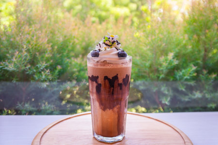 A beautiful chocolate milk coffee decorated with flowers, blueberries and cream cheese on a wooden...
