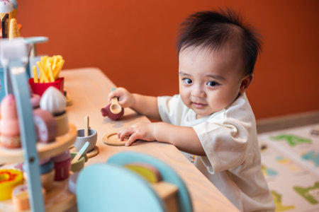 A cute little child smiles happily while playing with toys made from wood and non-toxic paint to...