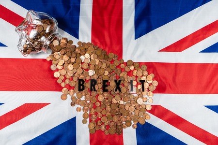 Brexit concept Union Jack and EU flag separated.Piggy coin bank on side,1p and 2p coins.の写真素材
